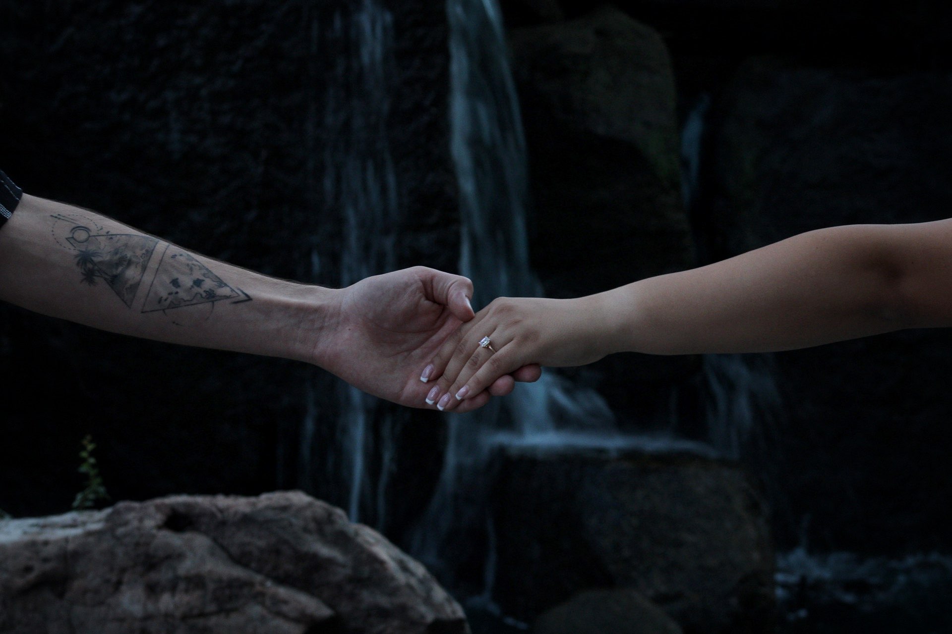 Couple reaching for each other's hands at dusk