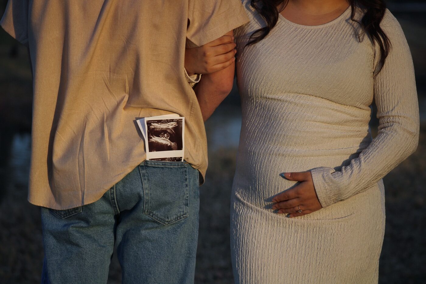 Close detail of ultrasound photo and pregnant belly