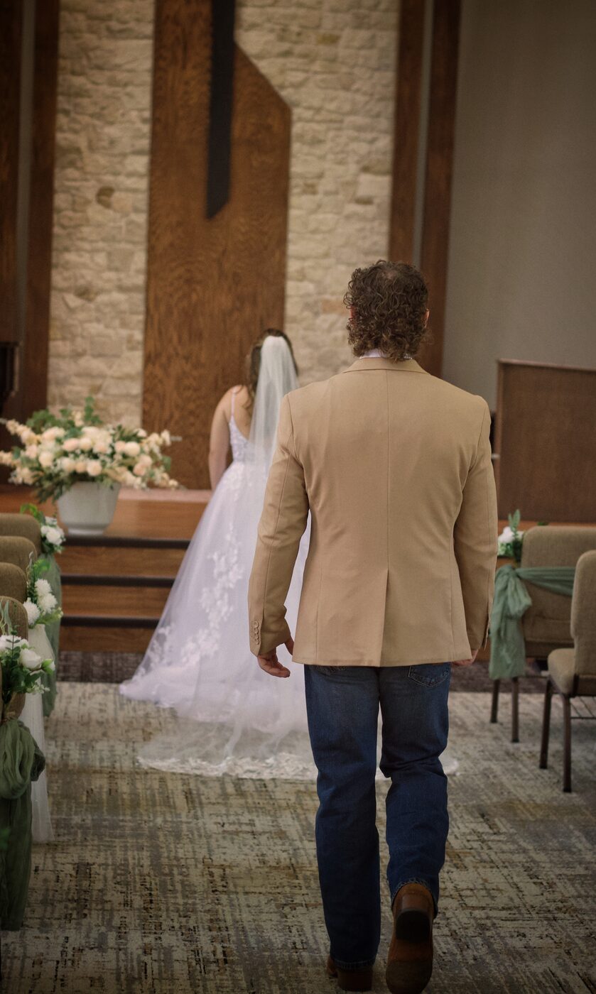 Groom walking the aisle toward his bride